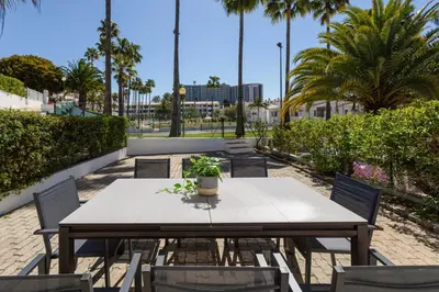 a patio with a table and chairs in front of a building at The Albufeira Concierge - Casa IÊ in Albufeira