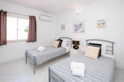 a bedroom with two beds and a window at Windmill by OCvillas in Albufeira