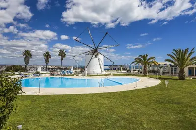 a windmill and a swimming pool with a windmill at Windmill by OCvillas in Albufeira