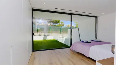 a bedroom with a bed and a large glass window at OneSixOne-Cleverdetails, Luxury villa, Sleeps 8 adults 2 children, Private pool and Jacuzzi in Vilamoura