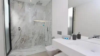 a white bathroom with a shower and a toilet at OneSixOne-Cleverdetails, Luxury villa, Sleeps 8 adults 2 children, Private pool and Jacuzzi in Vilamoura