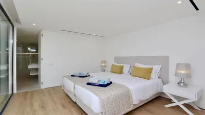 a white bedroom with a large white bed and a lamp at OneSixOne-Cleverdetails, Luxury villa, Sleeps 8 adults 2 children, Private pool and Jacuzzi in Vilamoura