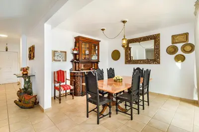 a dining room with a table and chairs and a mirror at Falésia Ocean Villa by The Portuguese Butler in Albufeira