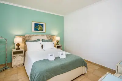 a bedroom with a large bed with two glasses on it at Falésia Ocean Villa by The Portuguese Butler in Albufeira