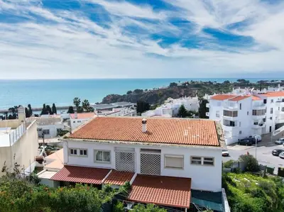 a white house with an orange roof and the ocean at Sea View Studio by Stay ici Algarve Holiday Rental in Albufeira