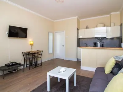 a living room with a couch and a table and a kitchen at Sea View Studio by Stay ici Algarve Holiday Rental in Albufeira