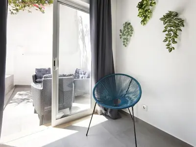 a blue chair in a room with a sliding glass door at Old Town II Apartment by Stay ici Algarve Holiday Rental in Albufeira