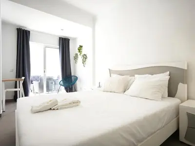 a bedroom with a white bed with a phone on it at Old Town II Apartment by Stay ici Algarve Holiday Rental in Albufeira