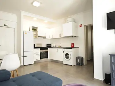 a kitchen with white cabinets and a washer and dryer at Old Town II Apartment by Stay ici Algarve Holiday Rental in Albufeira