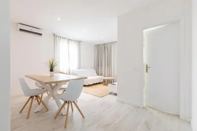 a white living room with a table and chairs at Apartamentos Baltum in Albufeira