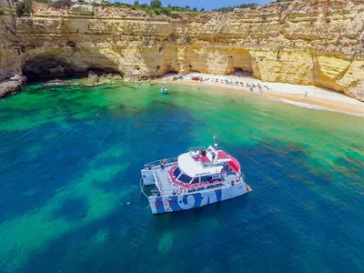 a boat in the water next to a beach at V4, Villa Jardins Branqueira7 near Beach, Albufeira in Albufeira