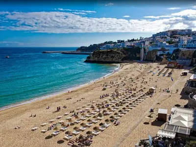 a beach with umbrellas and people on the beach at V4, Villa Jardins Branqueira7 near Beach, Albufeira in Albufeira