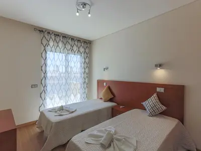 a bedroom with two beds and a window at V4, Villa Jardins Branqueira7 near Beach, Albufeira in Albufeira