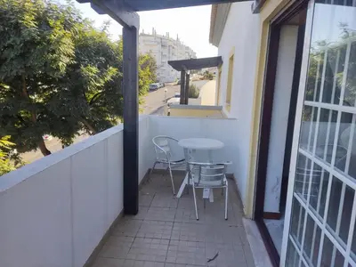 a patio with a table and chairs on a balcony at Large Duplex Apartment Pool View in Albufeira