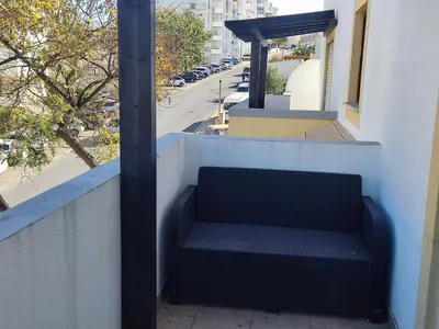 a bench sitting on the side of a building at Large Duplex Apartment Pool View in Albufeira