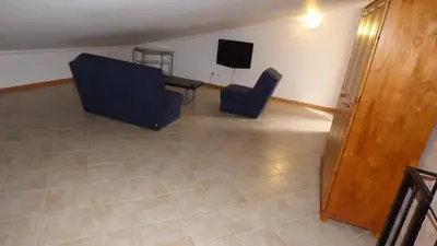 a living room with two chairs and a television at Large Duplex Apartment Pool View in Albufeira