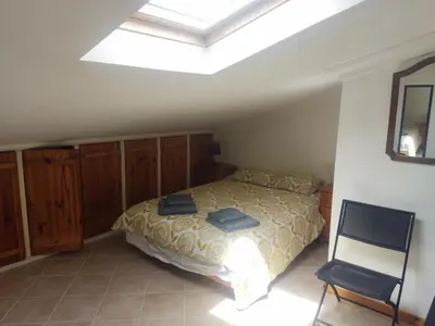 a bedroom with a bed and a skylight at Large Duplex Apartment Pool View in Albufeira