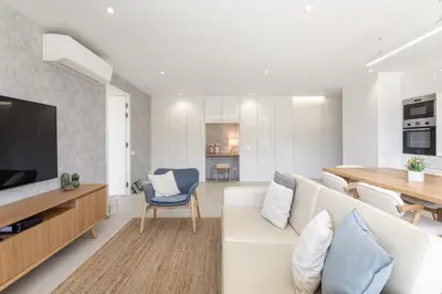 a living room with a white couch and a table at Hopstays - Vila das Lagoas - Salgados in Albufeira