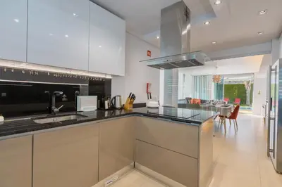 a kitchen with stainless steel appliances and a dining room at Casa ALBUFEIRA SUNSET in Albufeira