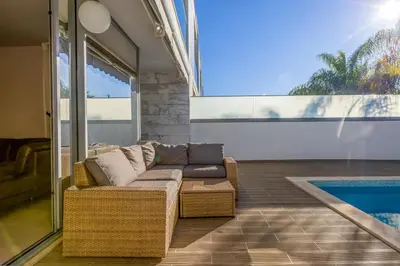a living room with a couch and a swimming pool at Casa ALBUFEIRA SUNSET in Albufeira