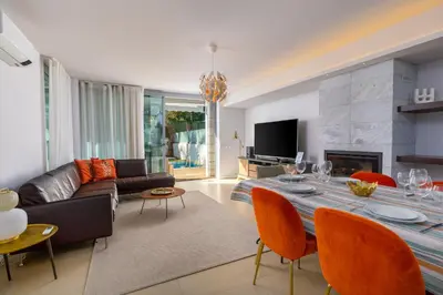a living room with a couch and a table with chairs at Casa ALBUFEIRA SUNSET in Albufeira