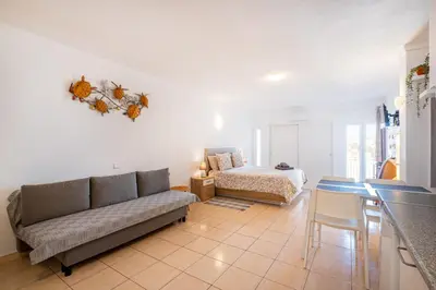 a living room with a couch and a bed at Beach Studio in Albufeira's old town in Albufeira