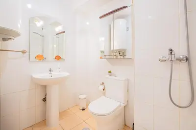 a white bathroom with a toilet and a sink at Beach Studio in Albufeira's old town in Albufeira