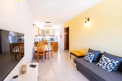 a living room with a couch and a dining room at Entire Apartment 5min from Oura Beach in Albufeira