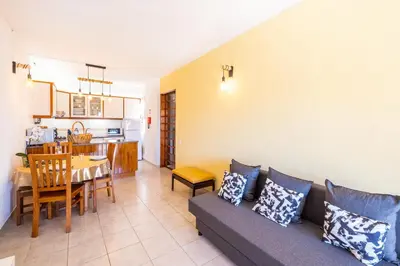 a living room with a couch and a dining room at Entire Apartment 5min from Oura Beach in Albufeira