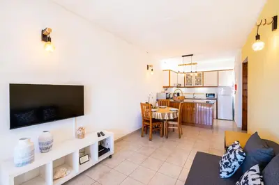 a living room with a couch and a dining room at Entire Apartment 5min from Oura Beach in Albufeira