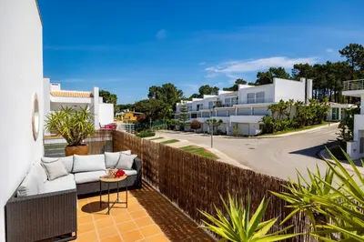 a balcony with a couch and a fence at Luxury Villa in Serene Location with Pool & Private Garden in Quarteira