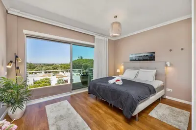 a bedroom with a bed and a large window at Luxury Villa in Serene Location with Pool & Private Garden in Quarteira