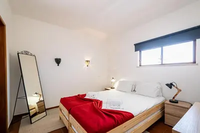 a bedroom with a bed with a red blanket on it at BeGuest Albufeira Visconde Apartment in Albufeira
