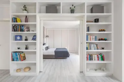a bedroom with a bed in a room with bookshelves at D_Loft in Albufeira