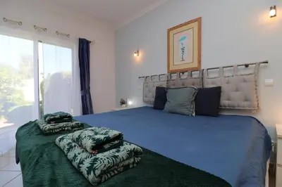 a bedroom with a large bed with pillows on it at Villa Jóia - 3 Bedroom Villa with Swimming pool in Boliqueime, near Vilamoura, Algarve in Boliqueime