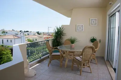 a patio with a table and chairs on a balcony at Vila Rosal Margarida Apartment in Albufeira