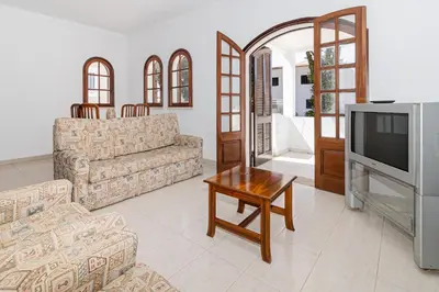 a living room with two couches and a tv at Villa Fineli in Vilamoura