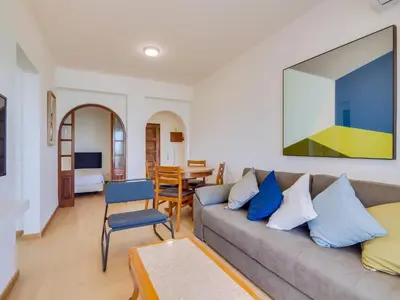 a living room with a couch and a table at AL - Apartamento Girassol Beach Front Quarteira in Quarteira