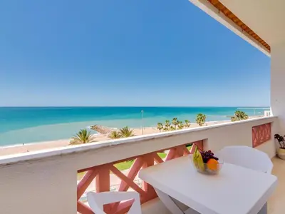 a balcony with a table and a view of the beach at AL - Apartamento Girassol Beach Front Quarteira in Quarteira