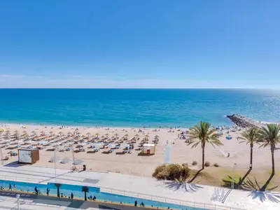 a beach with a lot of umbrellas and the ocean at AL - Apartamento Girassol Beach Front Quarteira in Quarteira