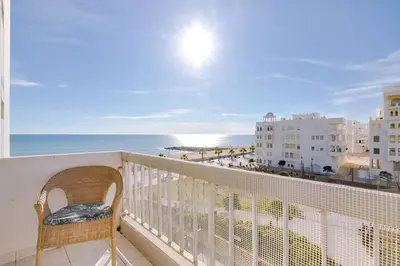 a balcony with a chair and a view of the ocean at Nascente Sea View @Homesbyfc in Quarteira
