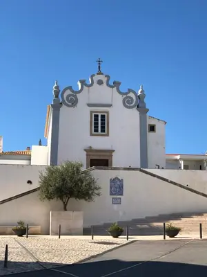 a white building with a cross on top of it at Apartamento Flor de Amendoeira in Albufeira