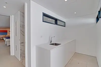 a bathroom with a sink in a white wall at One Six Villa in Vilamoura