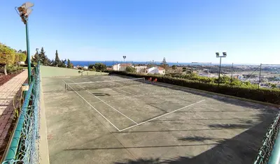 a tennis court with a net on top of it at AlbufeiraOrada Garden by Be Cherish in Albufeira