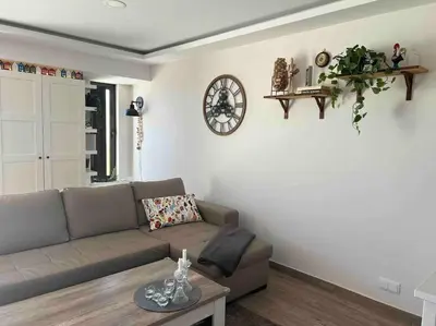 a living room with a couch and a clock on the wall at Casa Linda in Albufeira