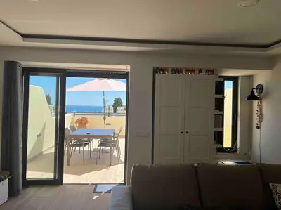 a living room with a couch and a table with an umbrella at Casa Linda in Albufeira
