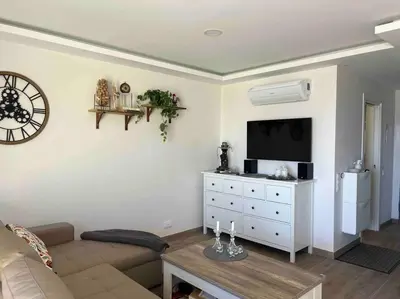 a living room with a couch and a flat screen tv at Casa Linda in Albufeira