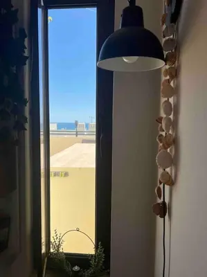 a lamp in a room with a view of a window at Casa Linda in Albufeira