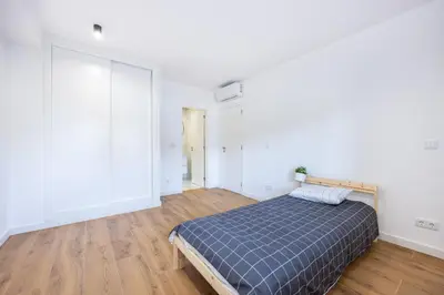 a bedroom with a bed and a wooden floor at Alfamar Inês Apartment in Albufeira