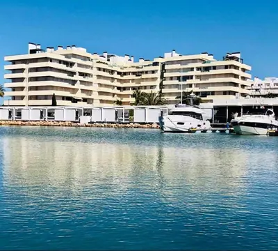 a large building with boats in a body of water at Marina Vilamoura - Aquamar 005 By Vilamoura Sun in Quarteira